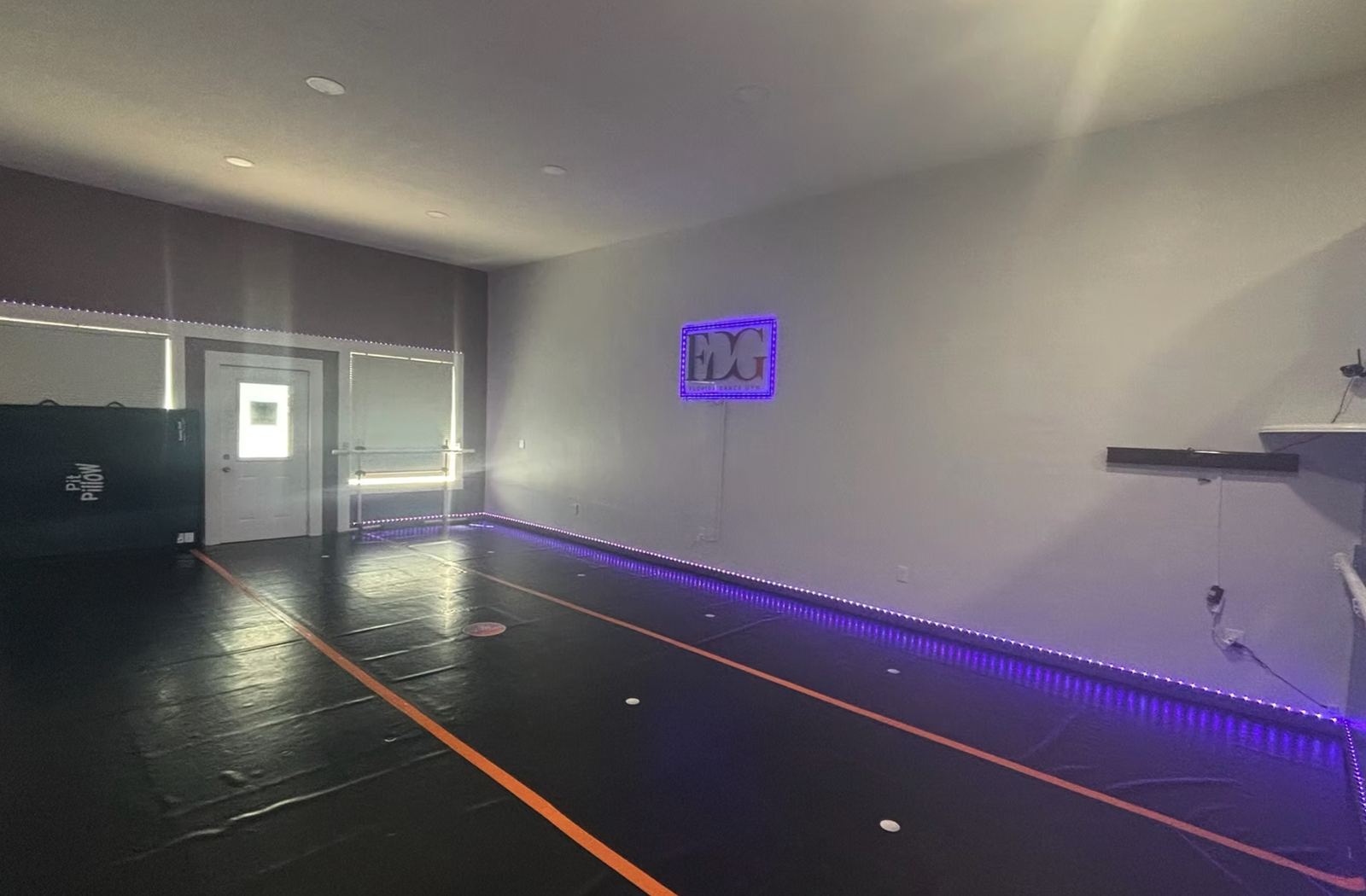 Florida Dance Gym studio floor with light-up FDG sign