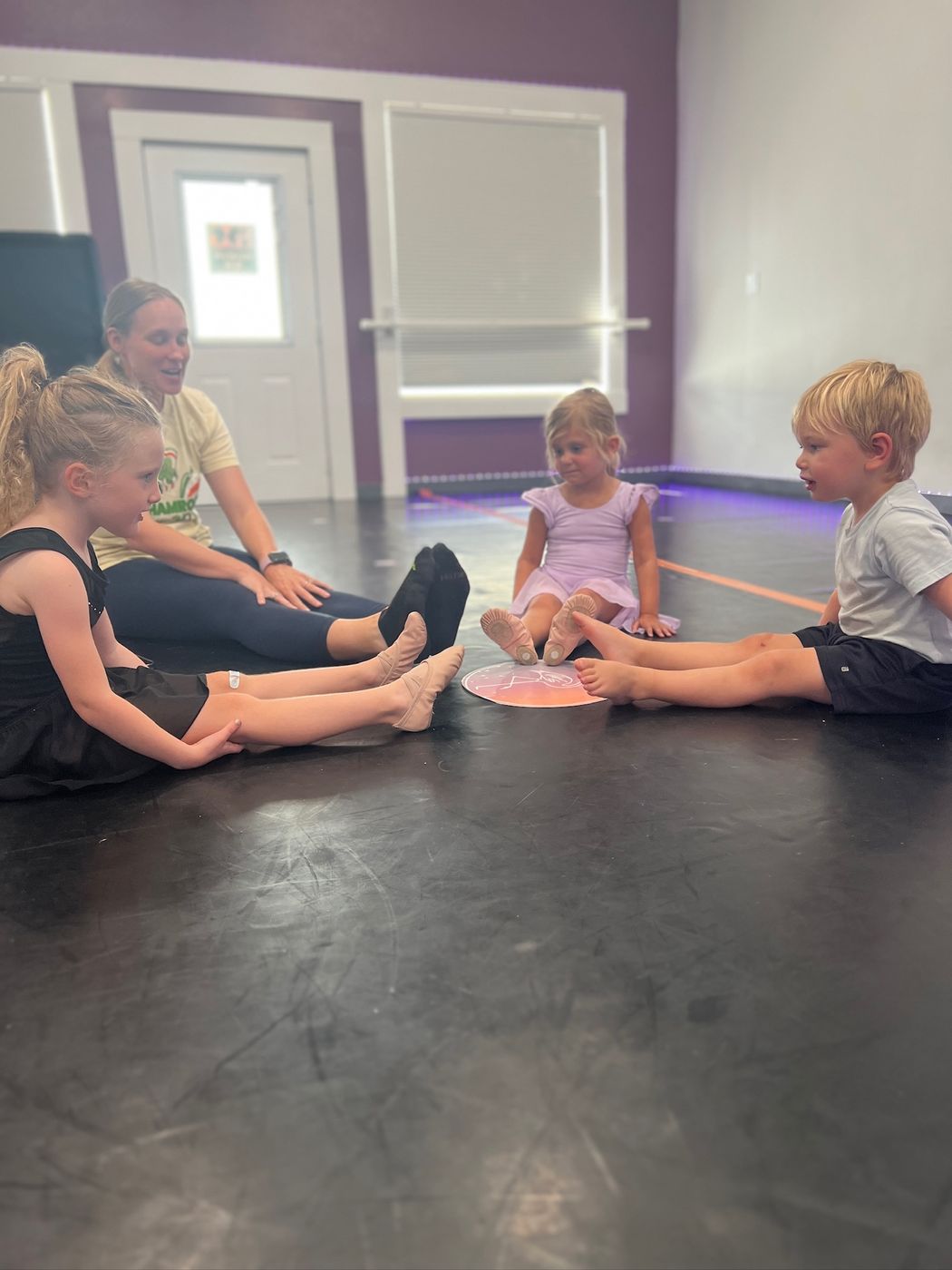 Florida Dance Gym teacher sitting with young dancers during class